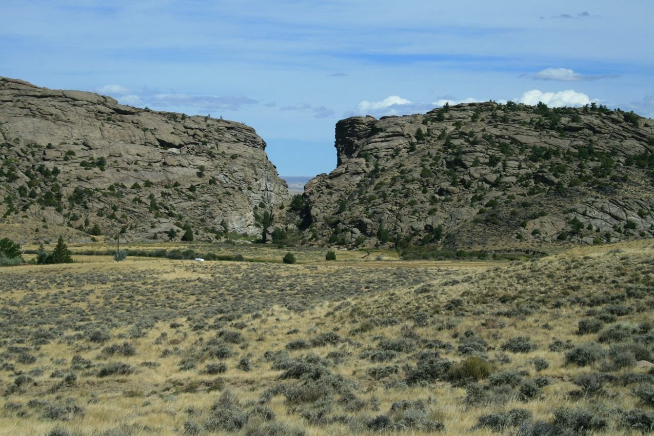 A rock buttress with a notch in it surrounded by sagebrush flats.