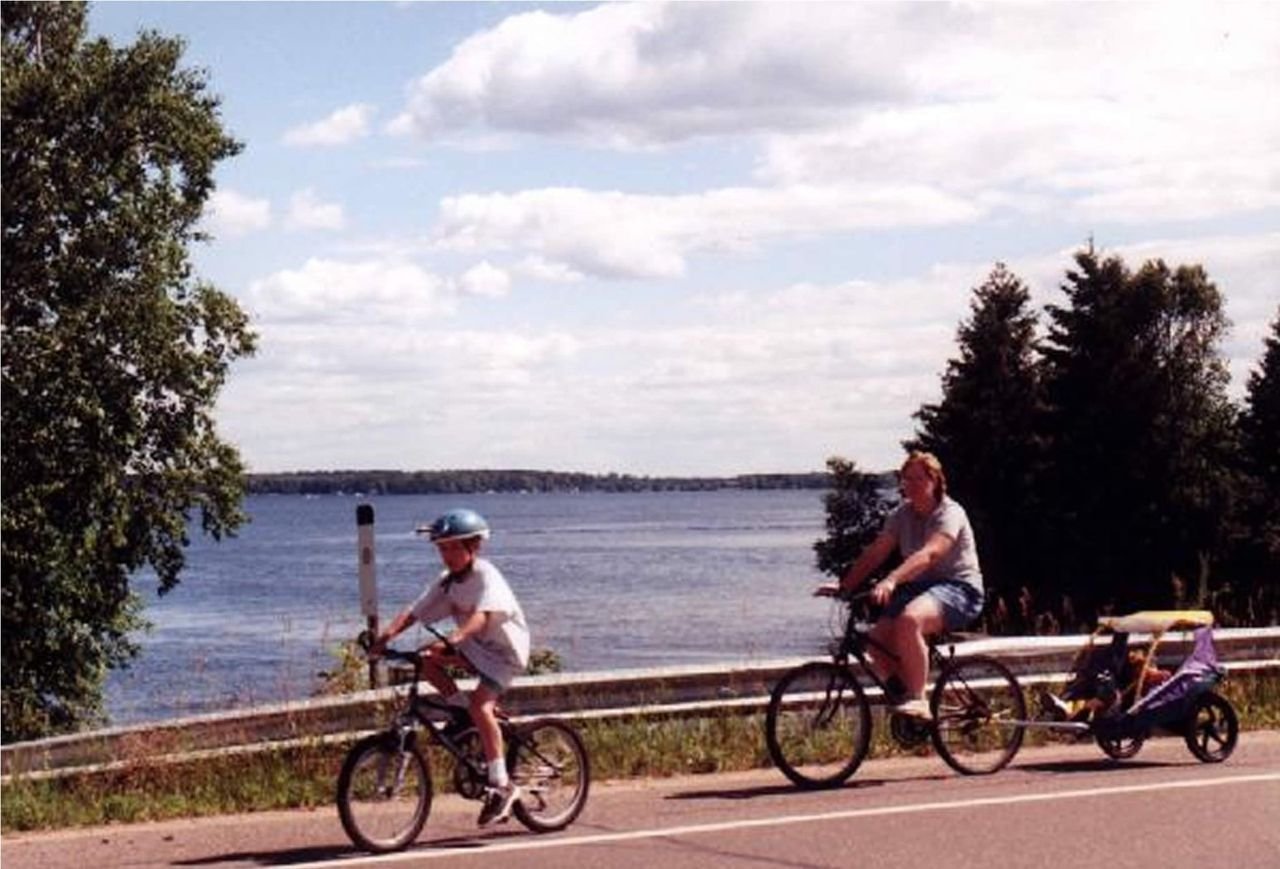 A family cycles past one of many lake views along Paul Bunyan Scenic Byway.