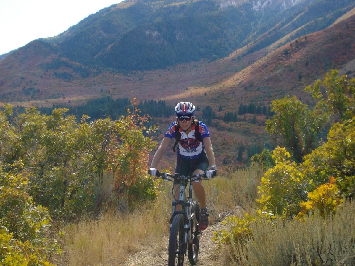 A mountain biker pedals through the fall colors and mountain vistas of Utah's Lower Payson Canyon.
