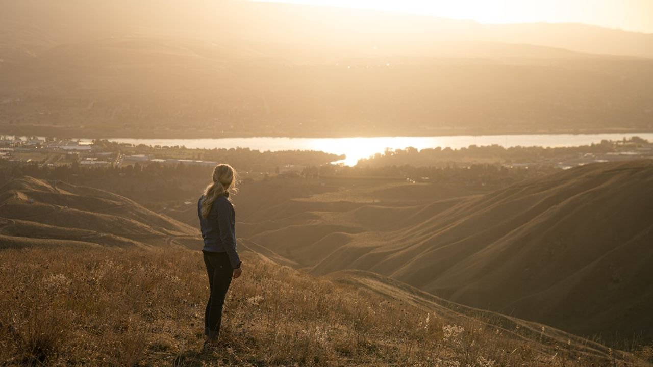 Woman hiking, overlooking the Wenatchee Valley in fall.