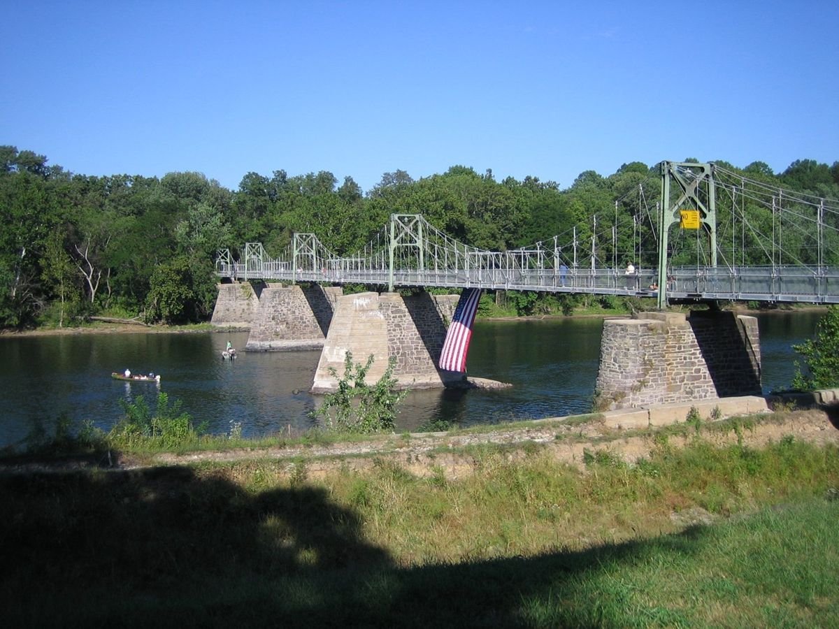 A scenic view of the Roebling Pedestrian Bridge at Lumberville/Raven Rock captures the beauty of the Delaware River and the Delaware River Scenic Byway. Roebling, who went on to build the Brooklyn Bridge in New York City, built this modern steel suspension bridge that sits on top of original 1855 stone abutments.